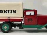 a red truck with a white cover on the back of it