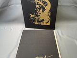 the book is sitting on a white sheet with a gold drawing on it