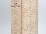 un livre à la couverture dorée posé sur une surface blanche