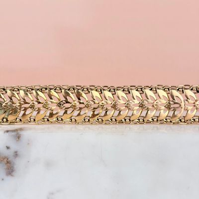 an image of a gold plated bracelet on a marble surface