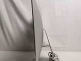 a computer monitor sitting on a stand with a cord