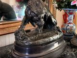 a bronze statue of a dog on a marble table