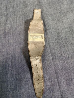 une photo d'une montre posée sur un tissu bleu