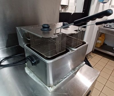 two deep fryers sitting on a counter in a kitchen