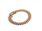 a close up of a gold bracelet on a white surface