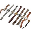 plusieurs types de montres sont alignés sur une surface blanche