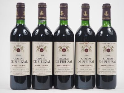 six bouteilles de vin sont alignées sur une surface blanche
