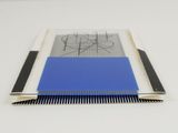 a close up of a blue and white comb on a white table
