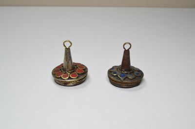 deux petites clochettes en métal posées sur une table blanche