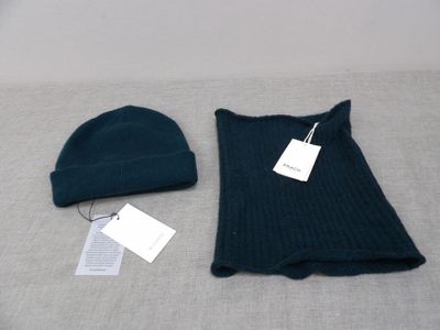 two hats and a sweater on a bed with a price tag