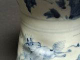 a blue and white vase with a cat on it