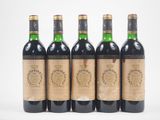 quatre bouteilles de vin sont alignées sur une surface blanche