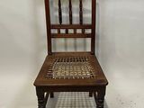 a wooden chair that has a woven seat on it
