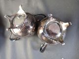 two silver teapots that are sitting on a table