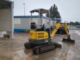 an image of a small excavator parked in a parking lot
