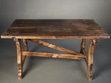 an old wooden table sitting on top of a gray floor