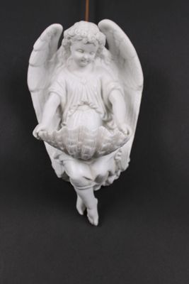 une statue d'ange tenant un panier de fleurs sur fond noir