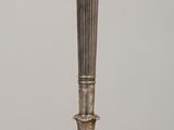 a silver candle holder sitting on a wooden table