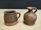 two brown vases sitting on a table next to each other
