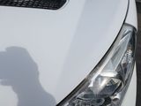 a shadow of a person on the hood of a white car