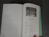 a person holding a book open on a table