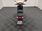 a motor scooter parked in a room with a checkered floor