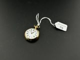 a close up of a gold pocket watch with a tag on it