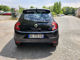 the back end of a black car parked on the side of a road