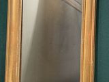 un miroir accroché au mur à côté d'un mur végétal