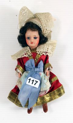 une poupée qui porte une robe et un chapeau