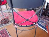 a chair with a red cushion on it in a room