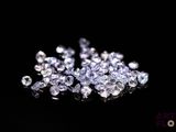 a close up of a bunch of diamonds on a black surface