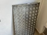 a metal basket that is sitting on the floor next to a wall
