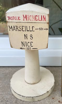 une affiche sur un poteau, à côté d'une bouteille de vin