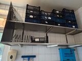 a metal shelf with baskets on it in a kitchen
