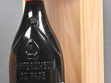 a bottle of wine in a wooden box next to a bottle of wine