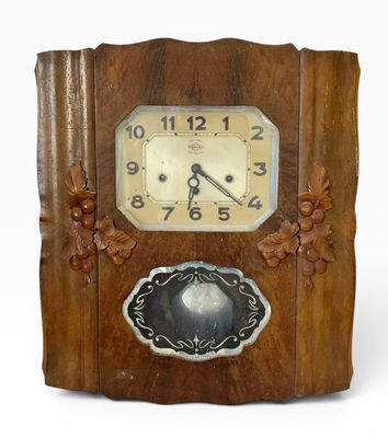 une horloge en bois exposée sur un fond blanc