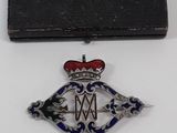 une image représentant une boîte noire sur laquelle figure une médaille argentée et rouge