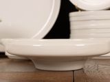 a white plate on a wooden table with a tea pot on it