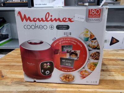 packaging of a red and white microwave cooker on a wooden table
