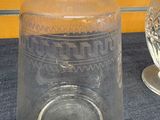 two glass vases sitting on a table next to each other