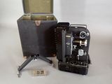 an old camera sitting next to a box on a tripod
