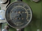 a close up of a gauge on the side of a green motorcycle