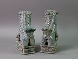 two figurines of lions that are sitting on top of each other