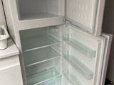 a white refrigerator with its door open in a kitchen