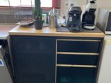 une petite cuisine équipée d'un réfrigérateur, d'un micro-ondes et d'autres appareils électroménagers