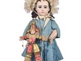 une poupée à l'ancienne, vêtue d'une robe bleue et d'un chapeau, tenant un ours en peluche