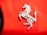ferrari logo on a red car with a clock in the background