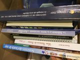 many books stacked on top of each other in a box