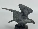 statue of a flying bird on a marble base on a white background